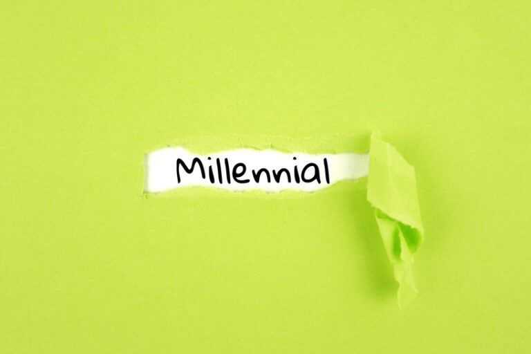 Word millennial exposed from behind a layer of lime green paper