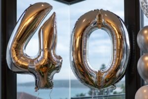 Silver 40th birthday balloons in front a of a window