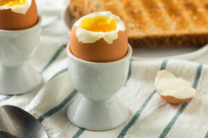 Homemade soft-boiled egg with toast on a striped tablecloth
