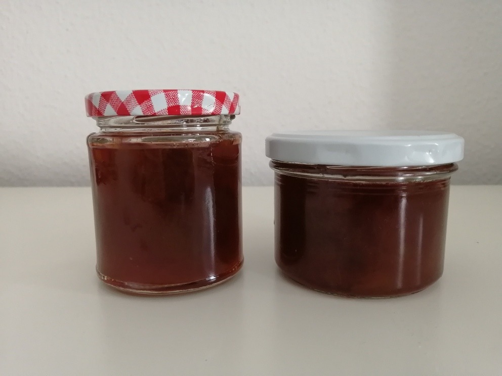 two jars of rhubarb and vanilla jam against a white background
