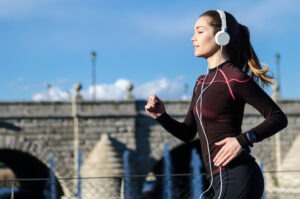 Young woman running listening to music on headphones