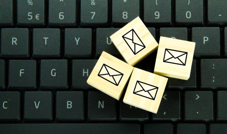 Close up of wooden blocks with envelope symbol sitting on a computer keyboard
