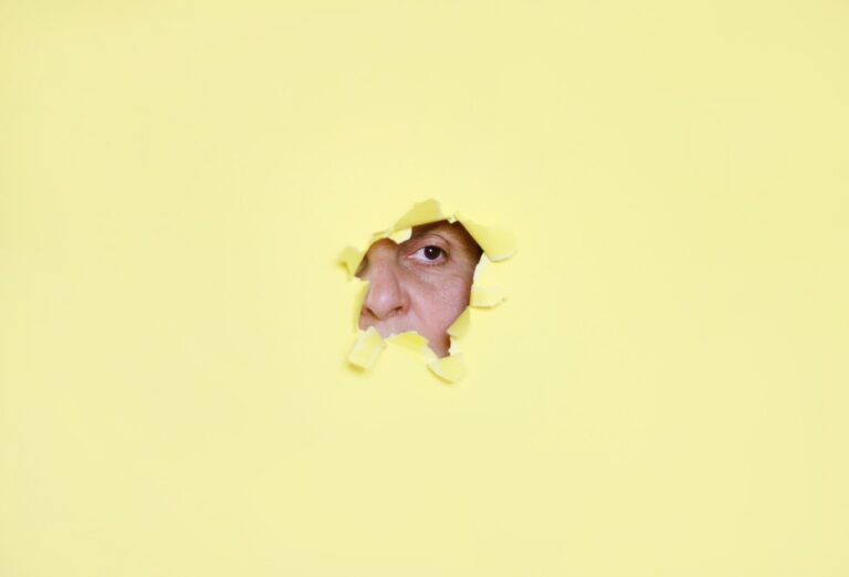 intj female peeking through hole in yellow paper