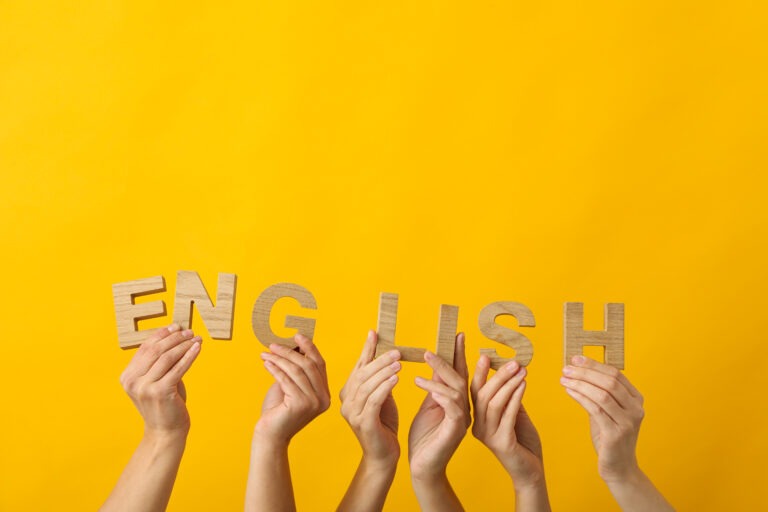 hands holding up wooden letters to spell the word English
