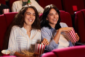 Laughing young women enjoying a movie at the flicks