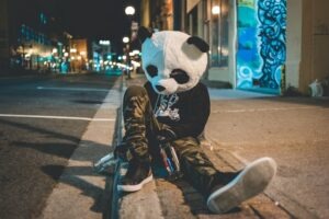Drunk person dressed as a panda sitting on the street